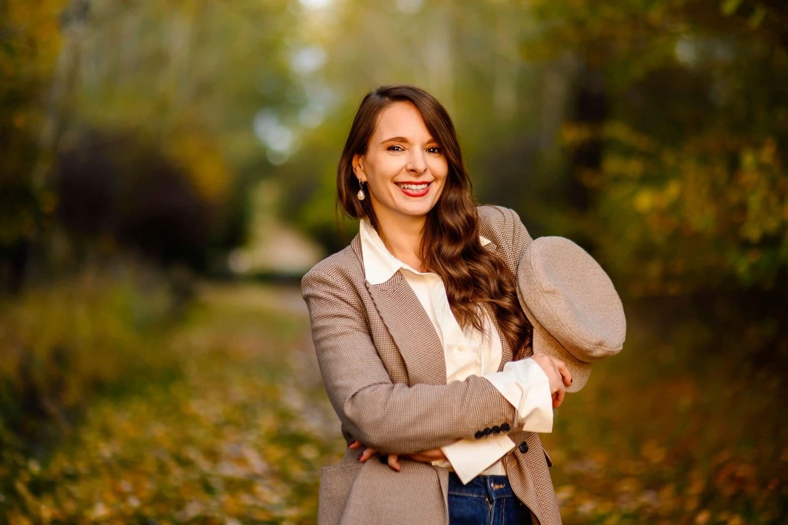 Alina Burlacu zâmbind, într-o alee cu frunze de toamnă